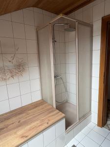 a shower in a bathroom with white tiles at Danner Appartements Regau - Möblierte Langzeit- & Monteurapartments nahe Gmunden, Laakirchen, Salzburg & Wels I Vollmöbliert & mit Parkplatz in Rutzenmoos