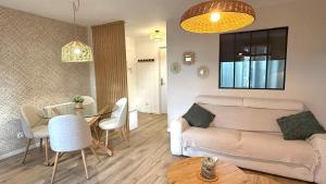 a living room with a couch and a table at Le Gingko in Montmerle Sur Saône