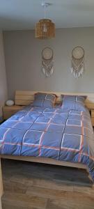 a bed with a blue comforter and two pillows at Maison Au 14 in Tours-sur-Marne