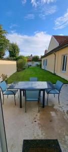 a picnic table and two chairs in a yard at Maison Au 14 in Tours-sur-Marne
