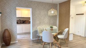 a dining room with a glass table and white chairs at Le Gingko in Montmerle Sur Saône