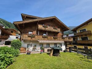 a large wooden house with a balcony and a yard at Pension Embacher GmbH & Co KG in Viehhofen