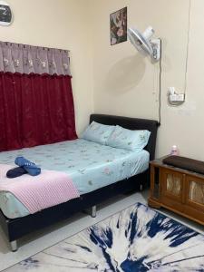 een slaapkamer met een bed en een rood gordijn bij Pinggiran Bayu Homestay in Kuantan