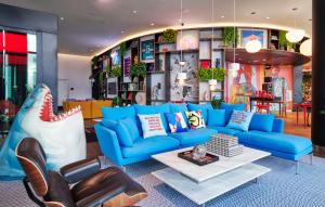 a living room with a blue couch and a table at citizenM Miami World Center in Miami +16 photos