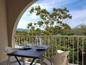 ein Tisch und zwei Stühle auf einem Balkon mit Aussicht in der Unterkunft Studio ensoleillé à Saint-Florent avec piscine in Saint-Florent