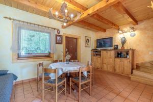 a dining room with a table and a tv at Pool & Wellness Twin Chalets Zavrh in Šimatovo