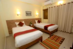 a hotel room with two beds and a rug at Hotel Dream Light in Pokhara