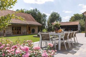 HarelbekeにあるHuswell - Authentic Serene Vacation Hideaway with Pondの花の咲く庭園のテーブルと椅子