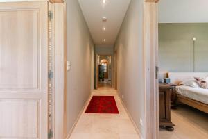 HarelbekeにあるHuswell - Authentic Serene Vacation Hideaway with Pondの赤い絨毯が敷かれた寝室に通じる廊下