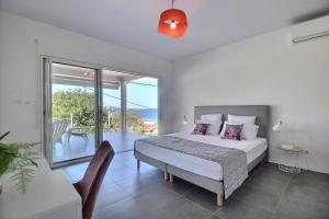 Villa Macaré في Quartier du Fond Fleuri: غرفة نوم مع سرير وشرفة +24 صورة
