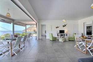 Villa Macaré في Quartier du Fond Fleuri: غرفة معيشة بها طاولة وكراسي