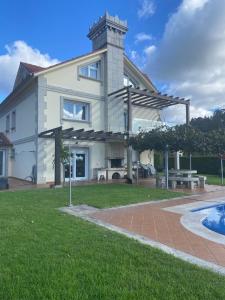 a large white house with a swimming pool at Casa Vacacional O PIÑEIRO in Piñeiro