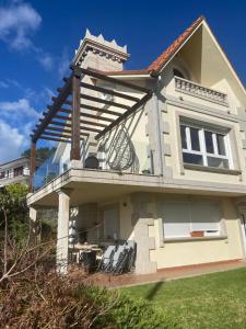 a house with chairs on the balcony of it at Casa Vacacional O PIÑEIRO in Piñeiro