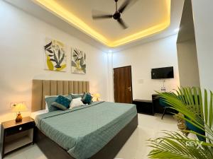 a bedroom with a bed with a ceiling fan at Wanna Ayodhya in Ayodhya