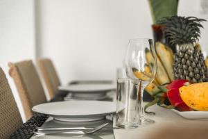 a table with a plate of fruit and a wine glass at Staylar Seaview Pool Villa Gina Chaweng Noi in Bophut  +24 photos