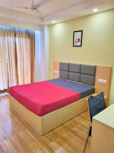 Un dormitorio con una cama grande con un colchón rojo. en Kommune Living, en Gurgaon