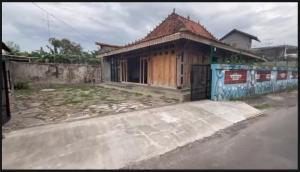 a small wooden house with a fence in front of it at Omah Masayu in Yogyakarta
