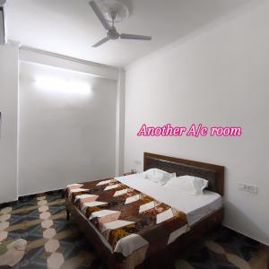 a bedroom with a bed and a ceiling fan at Hotel Shree Hari in Rishīkesh