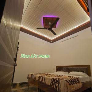 a bedroom with a ceiling fan and a bed at Hotel Shree Hari in Rishīkesh +5 photos