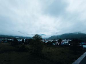a view of a city with clouds in the mountains at Hotel Shree Hari in Rishīkesh