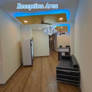 a reception area with a black leather couch in a room at Hotel Shree Hari in Rishīkesh
