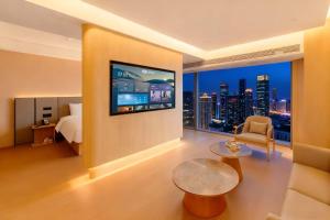 a hotel room with a bed and a tv on a wall at 先泽酒店 in Huadu