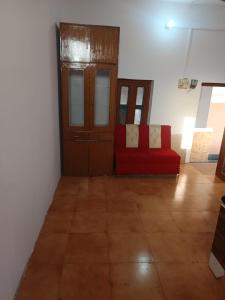 a living room with a red couch in a room at Astha Resturent pragti bhavan in Lucknow