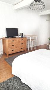 巴尔若尔Chambre d hotes "Lilimyna" avec petit déjeuner的卧室里有一张床和一台放在梳妆台上的电视 更多5张照片