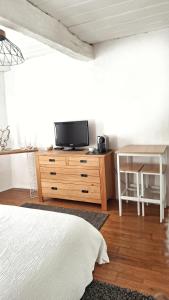 巴尔若尔Chambre d hotes "Lilimyna" avec petit déjeuner的卧室里有一张床和一台放在梳妆台上的电视