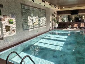 a large swimming pool in a room with a tile wall at Complex Chilingira in Osikovo