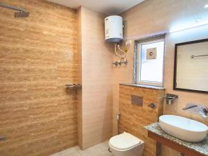 Un baño con lavabo, inodoro y ventana. en Kommune Living, en Gurgaon 12 fotos más