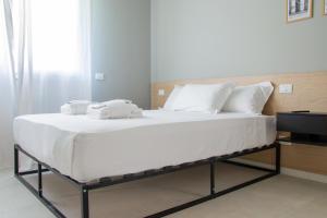 un grande letto bianco con asciugamani sopra in una stanza di Welc-ōM Green Building Business Padova a Padova