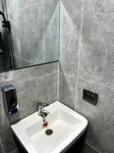 a bathroom with a white sink and a mirror at Lolo in Bishkek