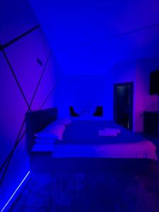 a bedroom with a bed with blue and purple lighting at Lolo in Bishkek