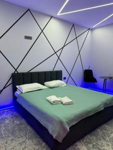 a bedroom with a bed with two towels on it at Lolo in Bishkek