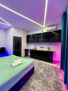 a bedroom with a bed and a sink and purple lighting at Lolo in Bishkek
