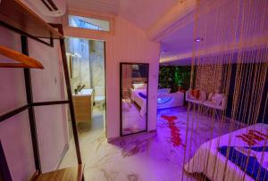 een badkamer met een bad en een slaapkamer met paarse verlichting bij Love Room romantique avec jacuzzi - Arles centre in Arles