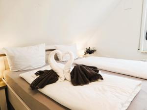 dos cisnes hechos de toallas sentadas en una cama en Ferienhaus Rerik Piratenlager, en Rerik