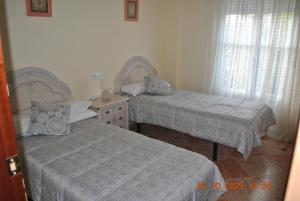 una camera da letto con due letti e una finestra di Casa Romo 2 a Rute Altre 17 foto