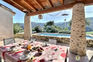 Saint-Fortunat-sur-EyrieuxChambres D'hôtes Mondon Le Haut的一个带游泳池的庭院里一张桌子,上面摆放着食物和饮料