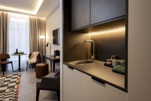 Una cocina con fregadero y una sala de estar. en The Hobson Cambridge by Adina, en Cambridge