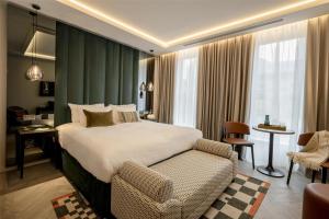 Un dormitorio con una cama y una silla en una habitación. en The Hobson Cambridge by Adina, en Cambridge