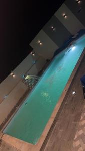 une grande piscine d'eau verte dans un bâtiment dans l'établissement Villa agadir, à Glalcha