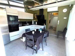 a kitchen with a black table and chairs in it at Gîte charles in Capbreton