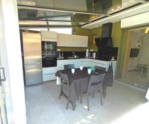 een keuken met een tafel met stoelen en apparatuur bij Gite charles in Capbreton +16 foto's