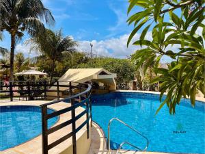 MangabeiraDunnas XXI By Holiday Stays的一个巨大的蓝色游泳池，背景是棕榈树