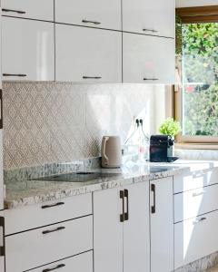 eine weiße Küche mit weißen Schränken und einem Fenster in der Unterkunft L'Eden d'Elynia Villa de Luxe avec piscine et front de mer in Rabat