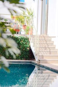 ein Swimmingpool mit Treppe und Pflanzen neben einem Haus in der Unterkunft L'Eden d'Elynia Villa de Luxe avec piscine et front de mer in Rabat