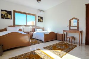 1 Schlafzimmer mit 2 Betten, einem Spiegel und einem Klavier in der Unterkunft L'Eden d'Elynia Villa de Luxe avec piscine et front de mer in Rabat + 65 Fotos