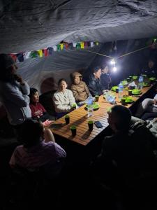 a group of people sitting around a table in a tent at Rinjani Vibe Bungalows in Tetebatu